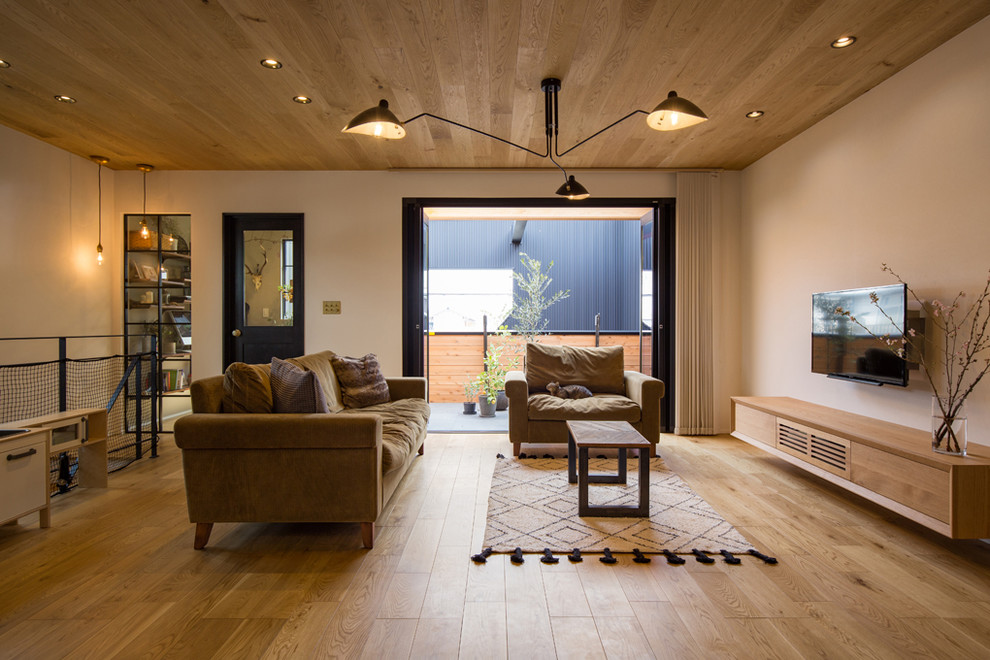 Offenes Asiatisches Wohnzimmer mit weißer Wandfarbe, braunem Holzboden, TV-Wand und braunem Boden in Nagoya