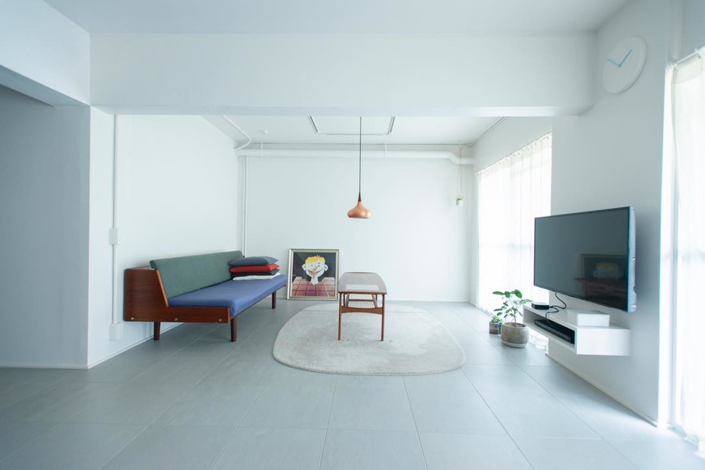 Design ideas for an urban living room in Tokyo with white walls, a wall mounted tv and grey floors.