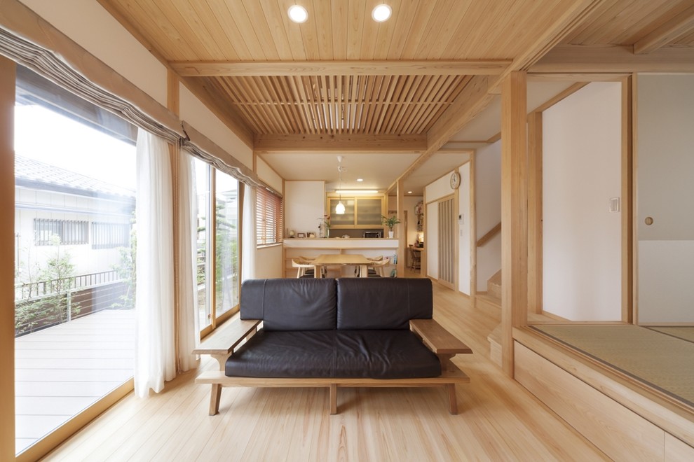 Ejemplo de salón abierto de estilo zen con paredes blancas, suelo de madera clara y suelo beige