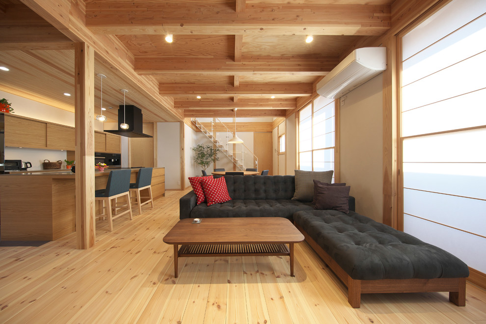 Esempio di un soggiorno etnico con pareti bianche, pavimento in legno massello medio e pavimento marrone