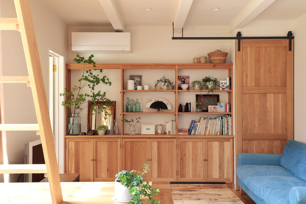 Imagen de salón abierto rústico con paredes blancas y suelo de madera en tonos medios