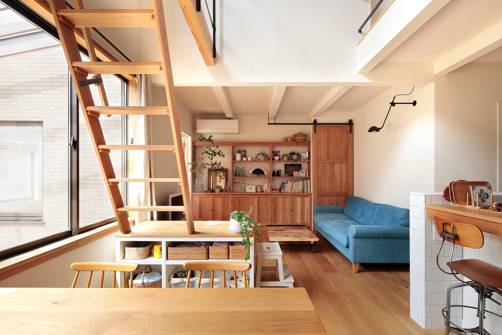 Offenes Nordisches Wohnzimmer mit weißer Wandfarbe, braunem Holzboden, freistehendem TV und braunem Boden in Yokohama