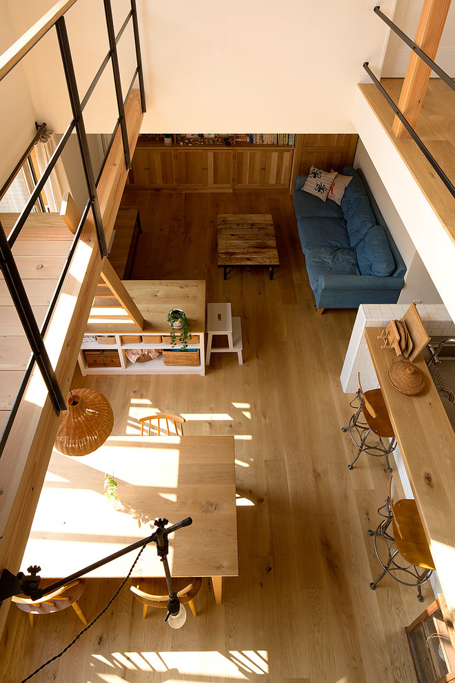 Пример оригинального дизайна: открытая гостиная комната в скандинавском стиле с белыми стенами и паркетным полом среднего тона