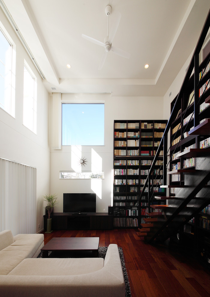 Modelo de salón minimalista con paredes blancas, suelo de madera oscura, televisor independiente y suelo marrón