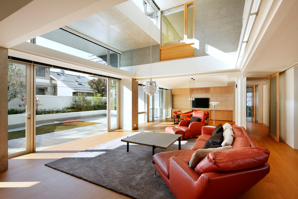 Ispirazione per un soggiorno contemporaneo con pareti bianche, pavimento in legno massello medio, TV a parete e pavimento marrone