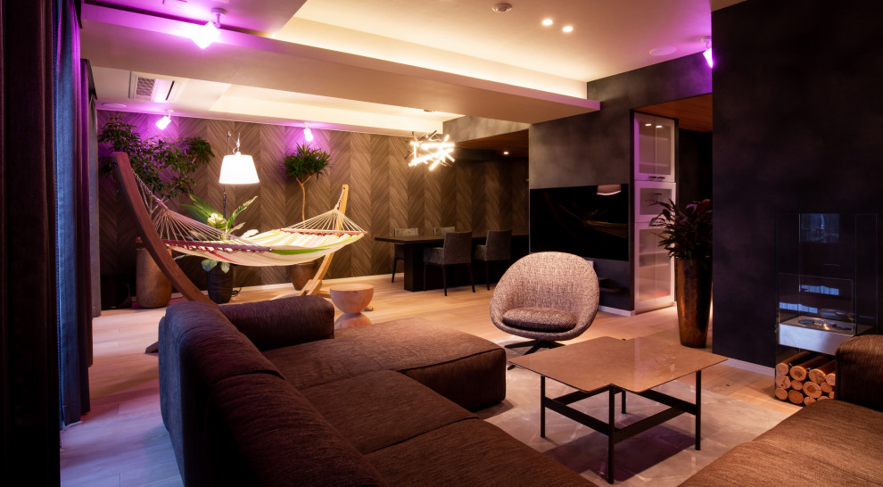 Esempio di un grande soggiorno design con pareti nere, TV a parete e pavimento grigio