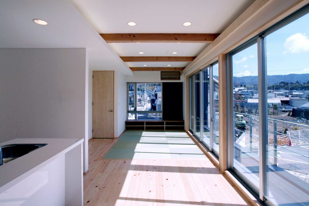 Cette image montre un petit salon asiatique ouvert avec un mur blanc et un sol de tatami.