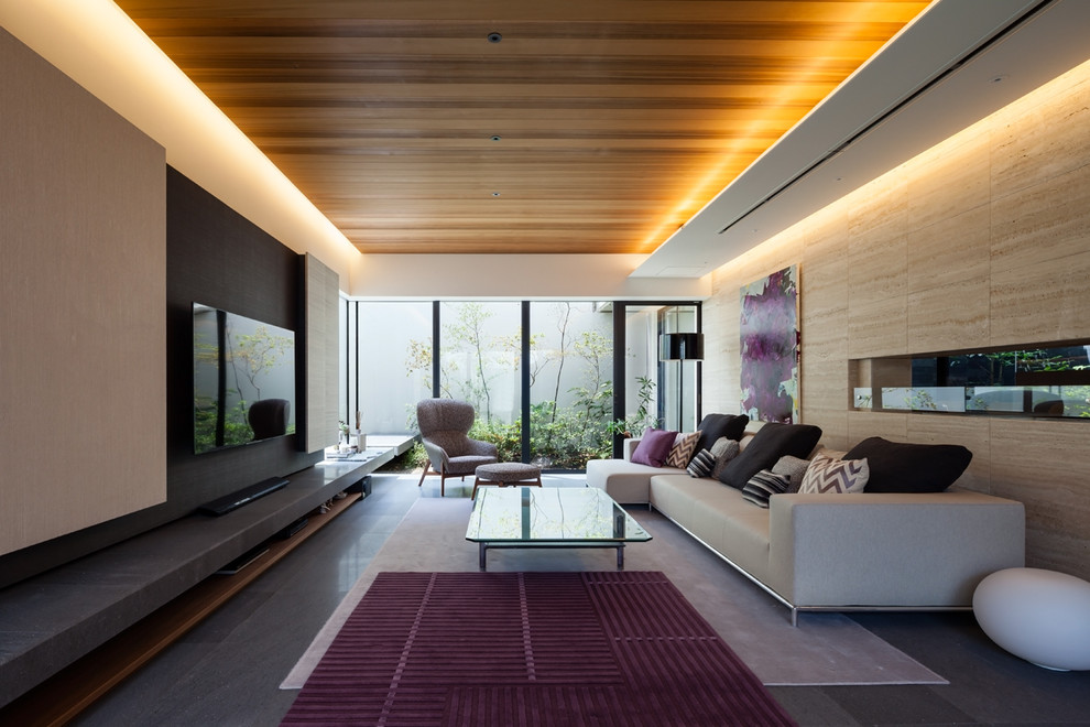 Diseño de salón abierto contemporáneo con paredes beige, televisor colgado en la pared y suelo gris