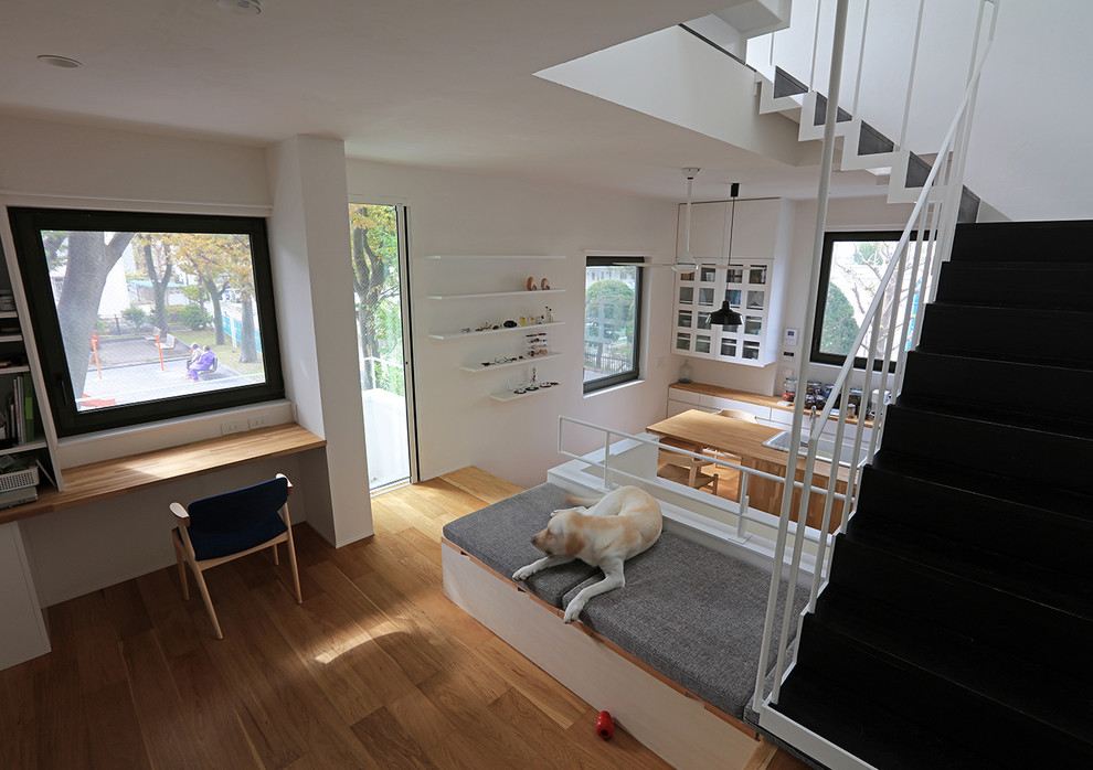 Foto di un piccolo soggiorno moderno aperto con pareti bianche, pavimento in legno massello medio, TV a parete e pavimento beige