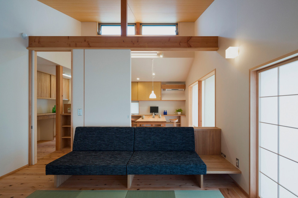 Offenes Asiatisches Wohnzimmer ohne Kamin mit weißer Wandfarbe, hellem Holzboden und braunem Boden in Sonstige