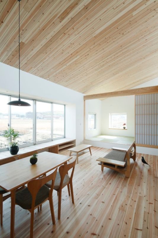 Réalisation d'un petit salon asiatique ouvert avec un mur blanc, un sol en bois brun et un sol beige.