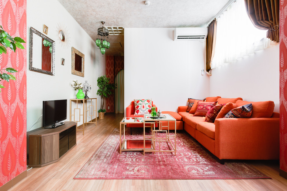 Diseño de salón para visitas abierto de estilo zen con paredes blancas, suelo de madera clara, televisor independiente y suelo beige