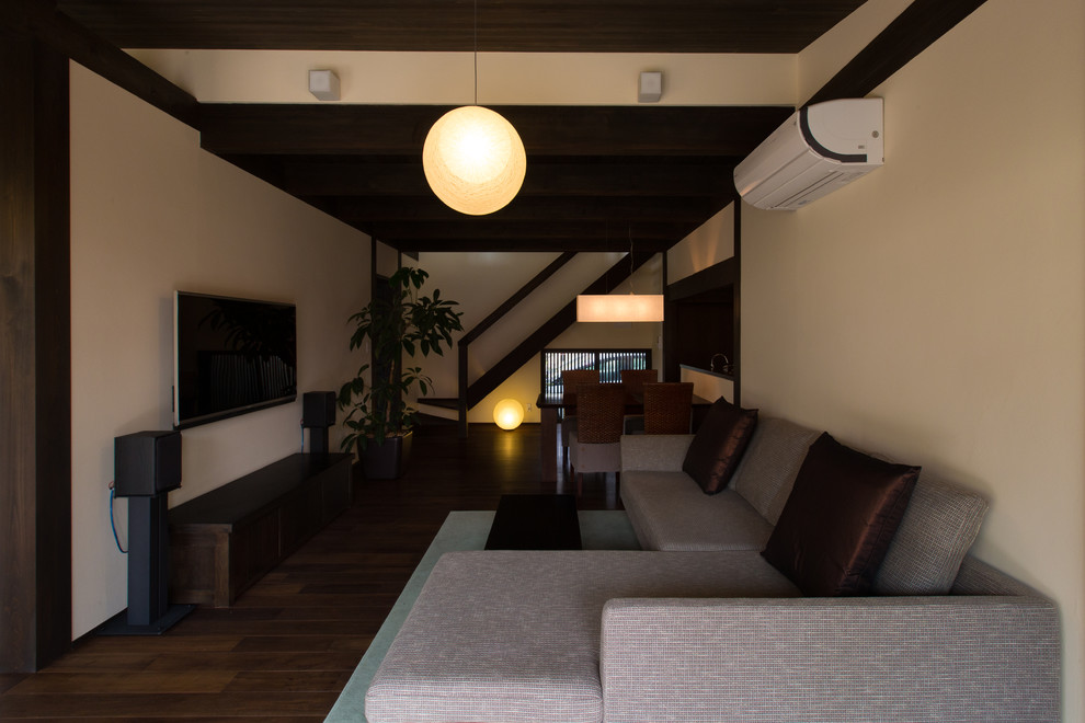 Inspiration for a world-inspired open plan living room in Nagoya with white walls, dark hardwood flooring, a wall mounted tv and brown floors.