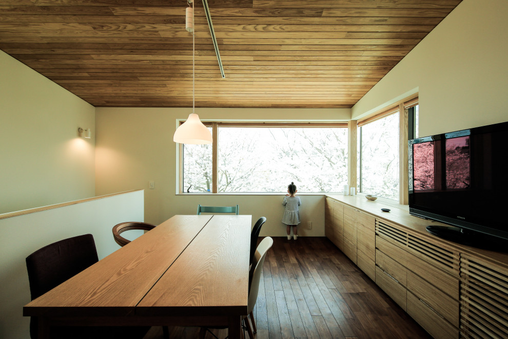 Diseño de salón abierto moderno con paredes blancas, suelo de madera oscura, televisor independiente y suelo marrón