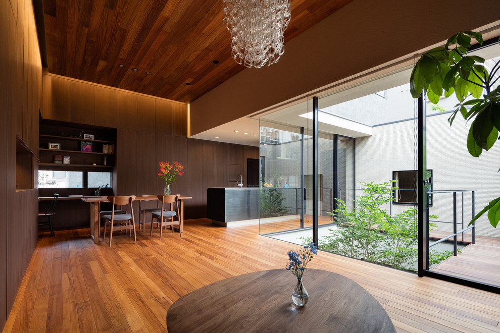 Foto de salón abierto moderno con paredes marrones, suelo de madera en tonos medios y suelo marrón