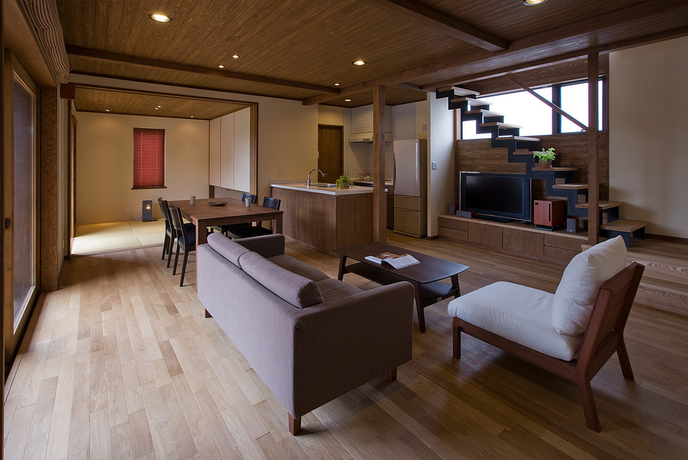 Cette image montre un salon design ouvert avec un sol en bois brun, un téléviseur indépendant, un mur marron et aucune cheminée.