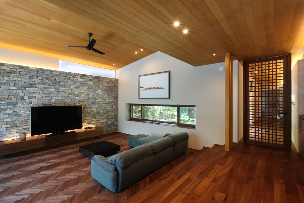 Inspiration pour un salon minimaliste avec un mur multicolore, parquet foncé, un téléviseur indépendant et un sol marron.