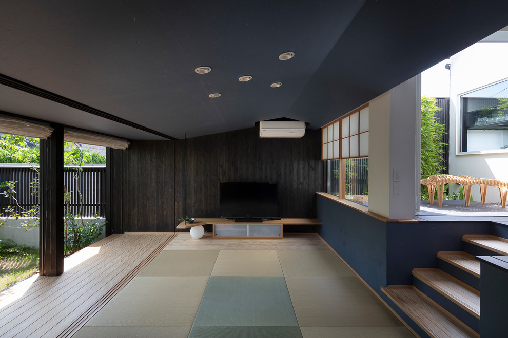福岡にあるアジアンスタイルのおしゃれなLDK (黒い壁、淡色無垢フローリング、ベージュの床) の写真