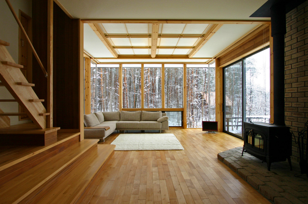 Asiatisches Wohnzimmer mit braunem Holzboden, freistehendem TV und braunem Boden in Tokio