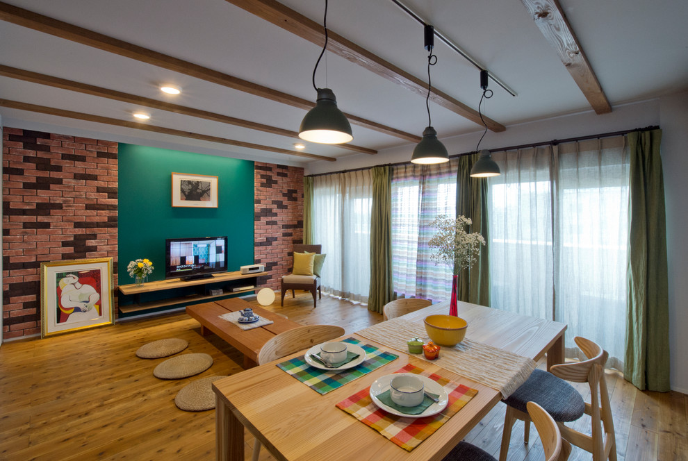 Cette image montre un salon asiatique ouvert avec un mur multicolore, un sol en bois brun, un téléviseur indépendant et un sol marron.