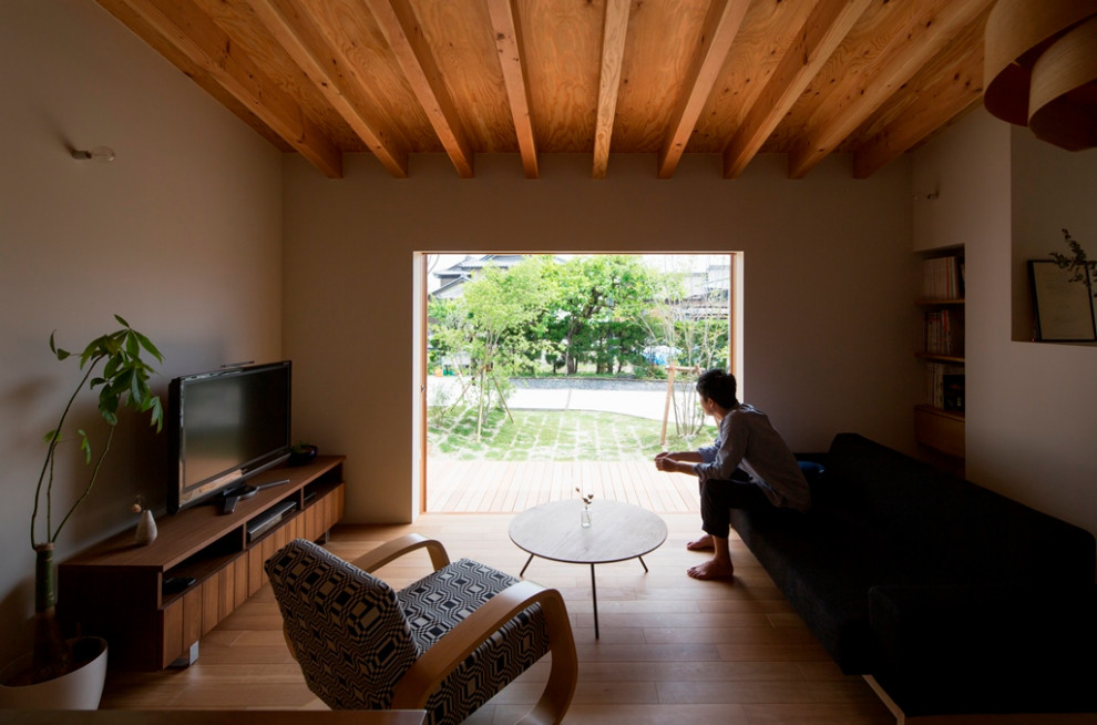 Immagine di un piccolo soggiorno moderno aperto con sala della musica, pareti bianche, pavimento in legno massello medio, TV autoportante, pavimento marrone e travi a vista
