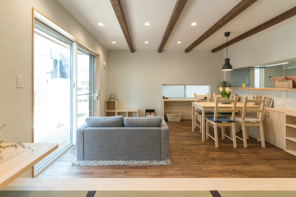 Immagine di un soggiorno etnico con pareti bianche, pavimento in legno massello medio e pavimento marrone