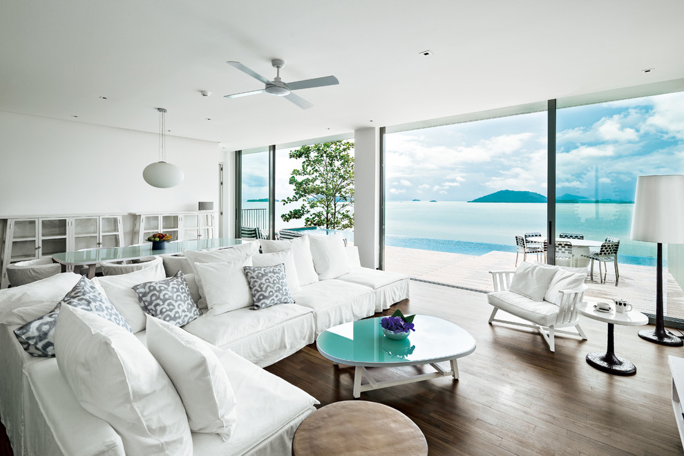 Cette photo montre un salon bord de mer ouvert avec un mur blanc et parquet peint.