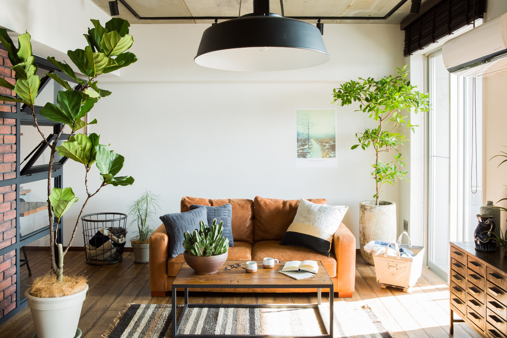 Industrial Wohnzimmer mit weißer Wandfarbe, braunem Holzboden und braunem Boden in Sonstige
