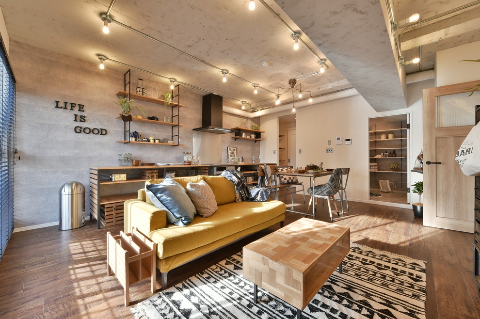 Exemple d'un salon industriel avec un mur gris, un sol en bois brun et un sol marron.
