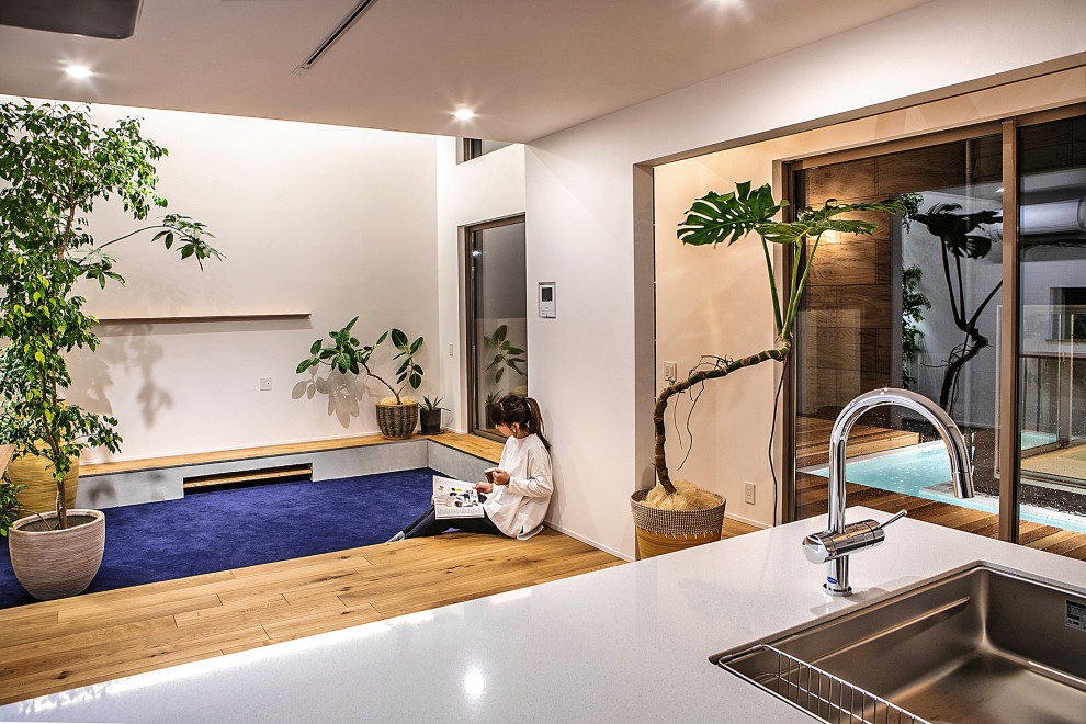 Offenes Modernes Wohnzimmer ohne Kamin mit weißer Wandfarbe, Teppichboden, TV-Wand, blauem Boden und Tapetendecke in Kyoto