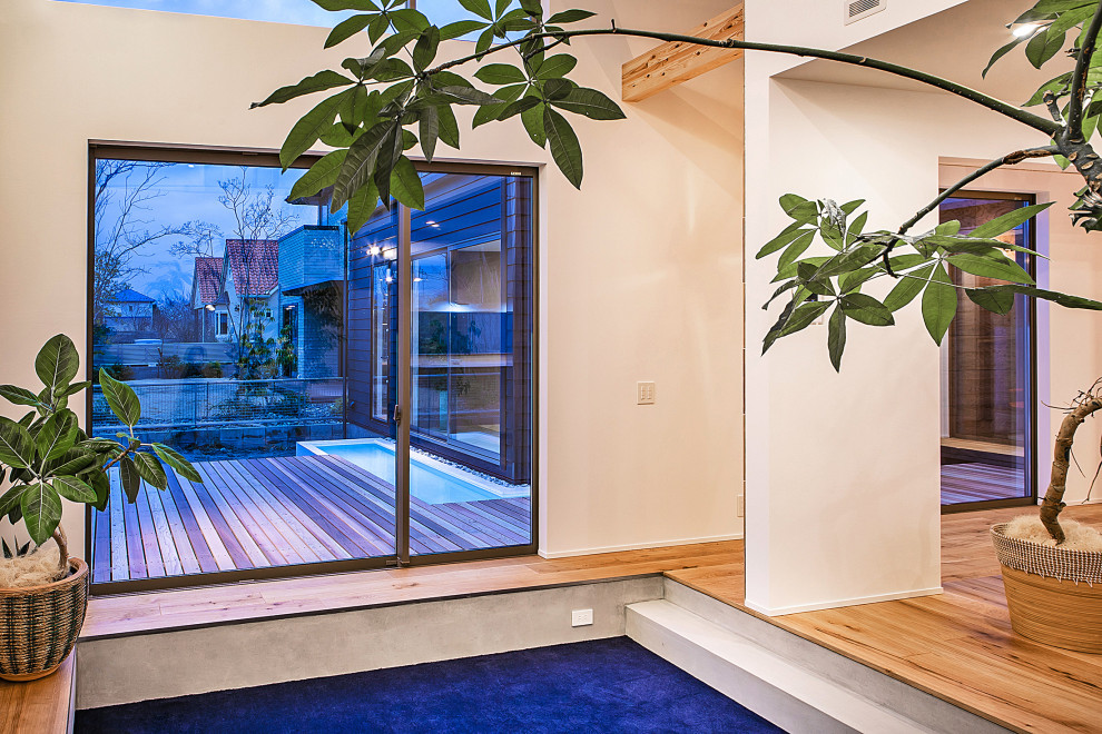Идея дизайна: открытая гостиная комната в современном стиле с белыми стенами, ковровым покрытием, телевизором на стене, синим полом и потолком с обоями без камина