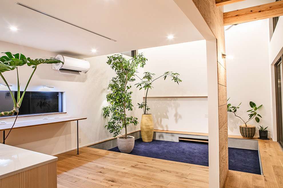 Идея дизайна: открытая гостиная комната в современном стиле с белыми стенами, ковровым покрытием, телевизором на стене, синим полом и потолком с обоями без камина