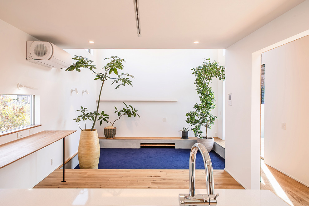 Idée de décoration pour un salon design ouvert avec un mur blanc, moquette, aucune cheminée, un téléviseur fixé au mur, un sol bleu et un plafond en papier peint.