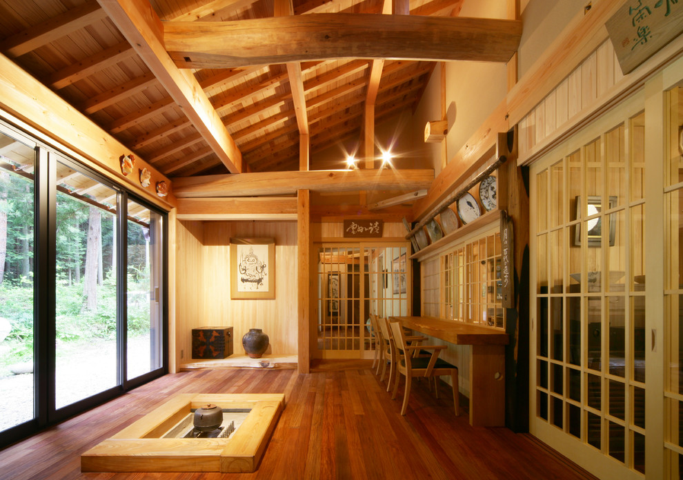 Cette image montre un salon asiatique avec un mur marron, un sol en bois brun et un sol marron.