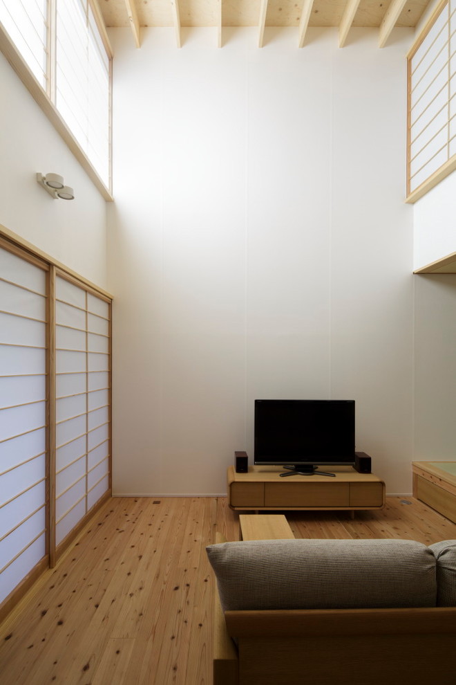 Offenes Wohnzimmer mit weißer Wandfarbe, hellem Holzboden und freistehendem TV in Tokio