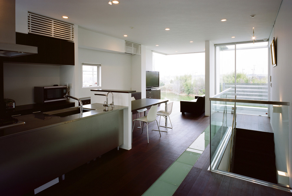 Photo of a contemporary living room in Osaka with white walls, dark hardwood flooring, a freestanding tv and brown floors.