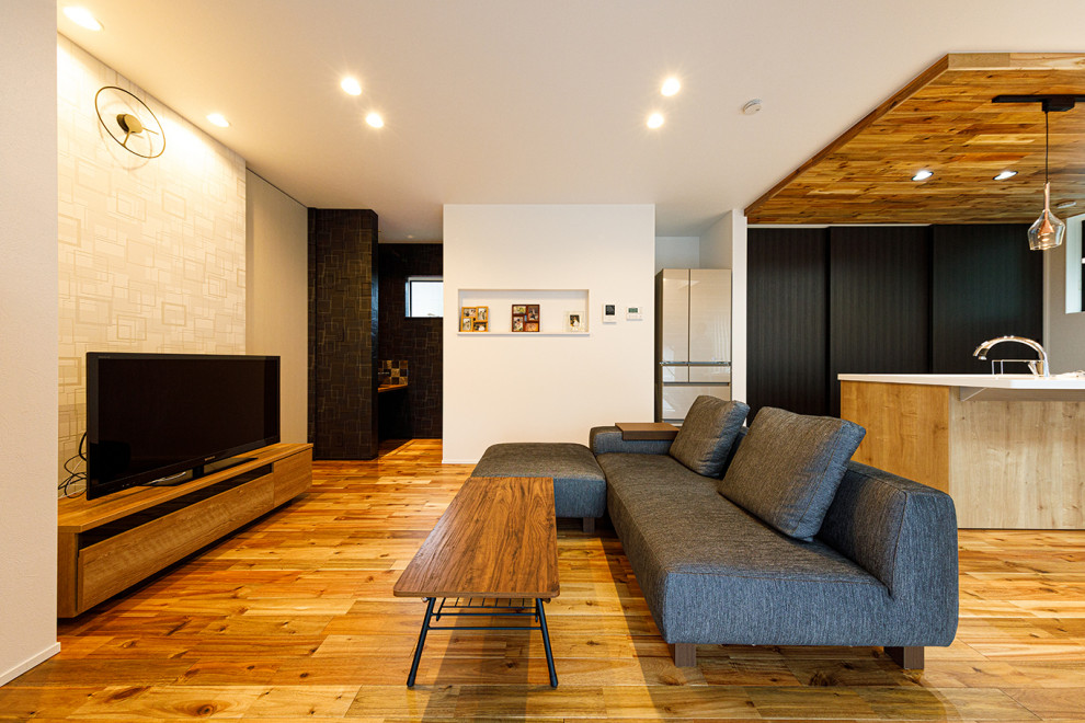 Imagen de salón para visitas abierto minimalista de tamaño medio con paredes blancas, suelo de madera oscura, televisor independiente y suelo rosa
