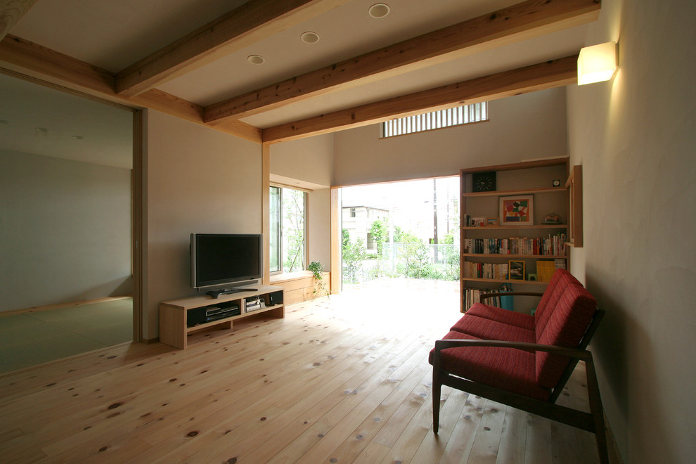 Imagen de salón abierto de estilo zen de tamaño medio con paredes blancas, suelo de madera clara y televisor independiente