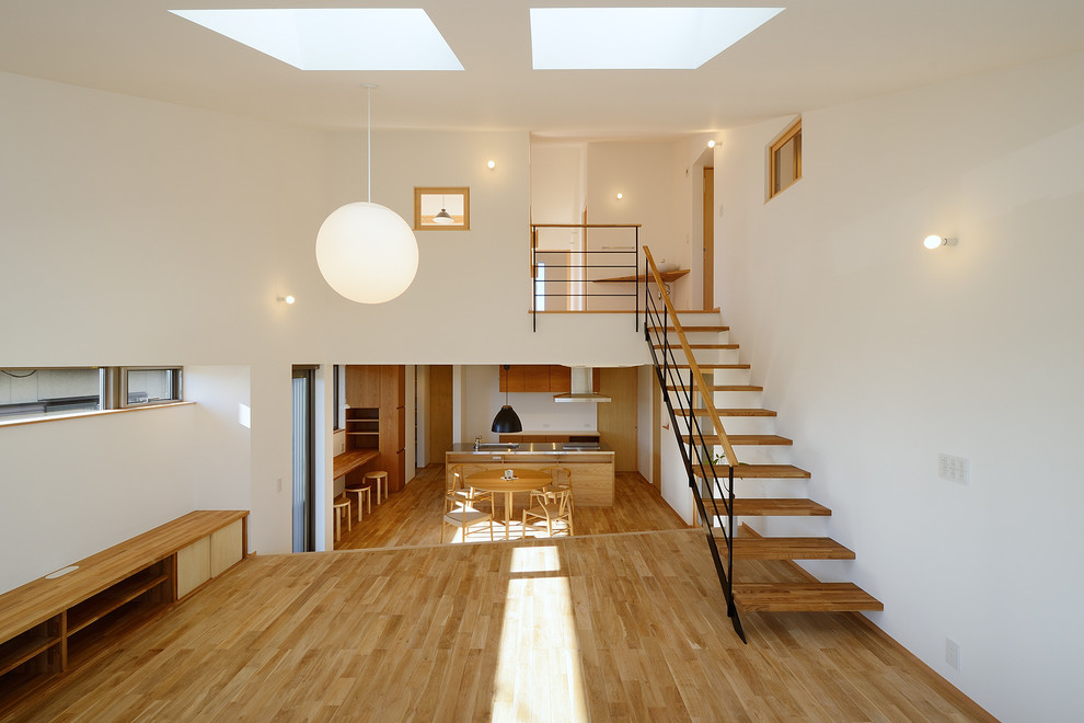 Skandinavisches Wohnzimmer mit hellem Holzboden und braunem Boden in Sonstige