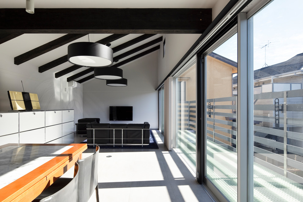 Esempio di un soggiorno minimal aperto con pareti bianche, pavimento in gres porcellanato, TV a parete e pavimento beige