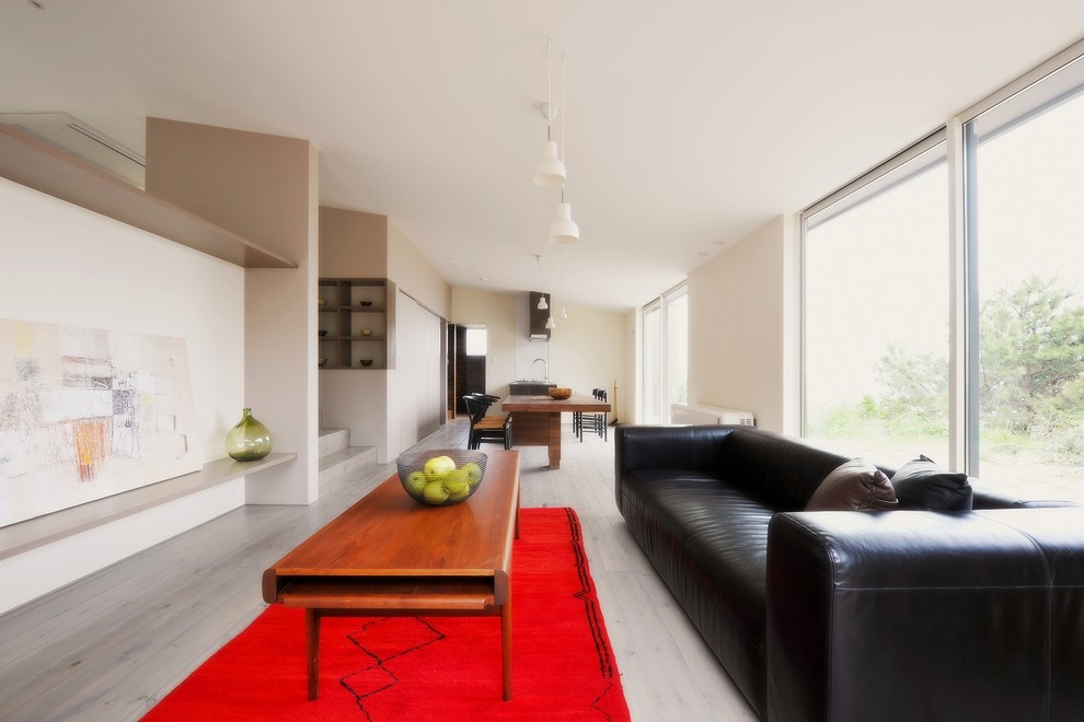 Свежая идея для дизайна: открытая гостиная комната в стиле модернизм с белыми стенами, деревянным полом и серым полом - отличное фото интерьера