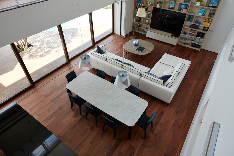 Großes, Repräsentatives, Offenes Modernes Wohnzimmer ohne Kamin mit weißer Wandfarbe, braunem Holzboden und Multimediawand in Sonstige