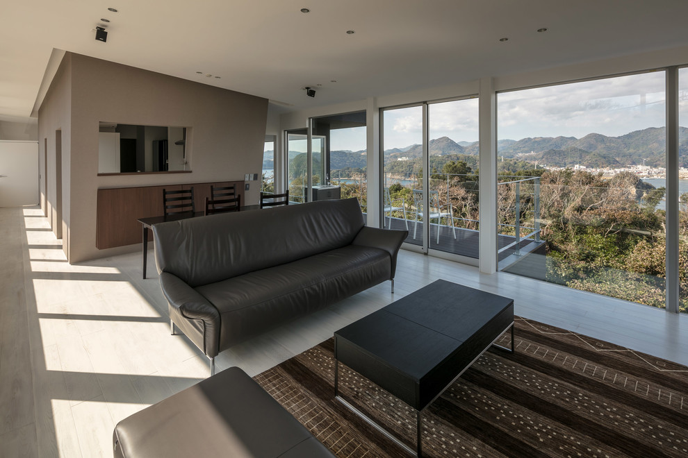 Пример оригинального дизайна: открытая гостиная комната в стиле модернизм с белыми стенами, деревянным полом, отдельно стоящим телевизором и серым полом