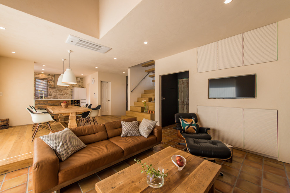 This is an example of a contemporary open plan living room in Tokyo with white walls, terracotta flooring, a built-in media unit and brown floors.