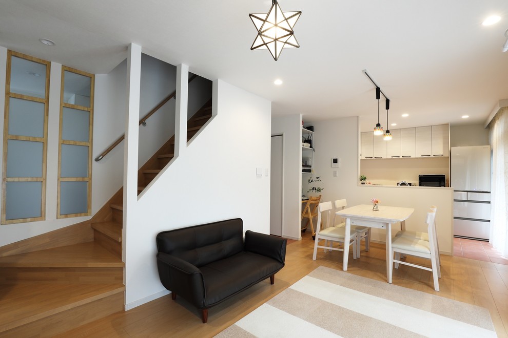 Foto di un soggiorno moderno di medie dimensioni e aperto con pareti bianche, pavimento in compensato, nessun camino, TV autoportante e pavimento beige