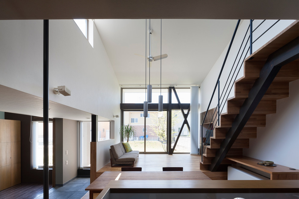 Asiatisches Wohnzimmer ohne Kamin mit weißer Wandfarbe, braunem Holzboden und freistehendem TV in Tokio Peripherie