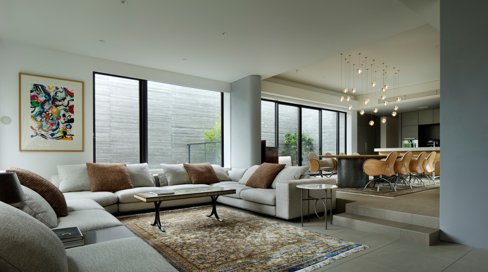 Immagine di un grande soggiorno minimalista aperto con pareti bianche, pavimento con piastrelle in ceramica e pavimento grigio