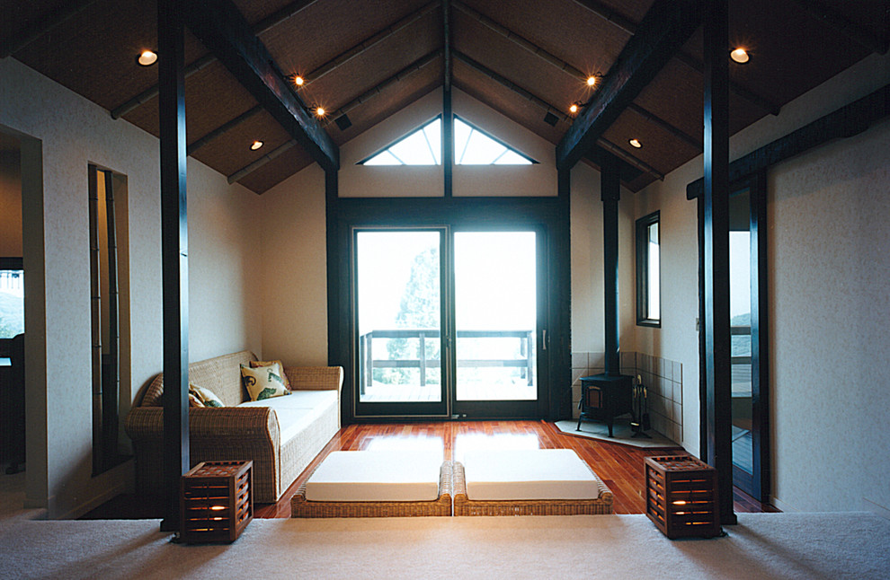 Modelo de salón abierto asiático con suelo de madera oscura, marco de chimenea de baldosas y/o azulejos y suelo rojo