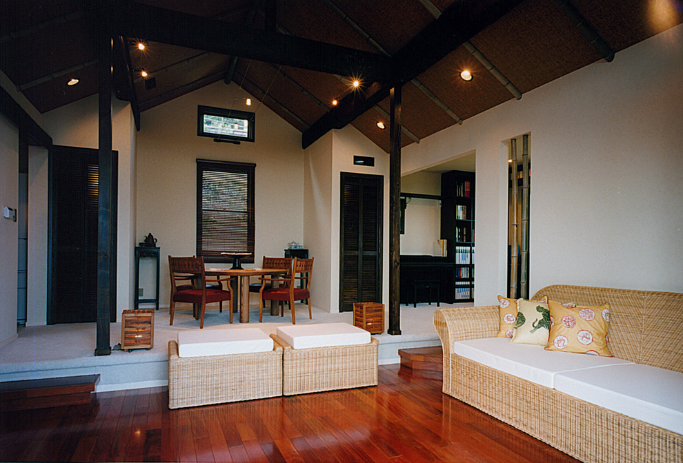 Offenes Asiatisches Wohnzimmer mit dunklem Holzboden, gefliester Kaminumrandung und rotem Boden in Sonstige
