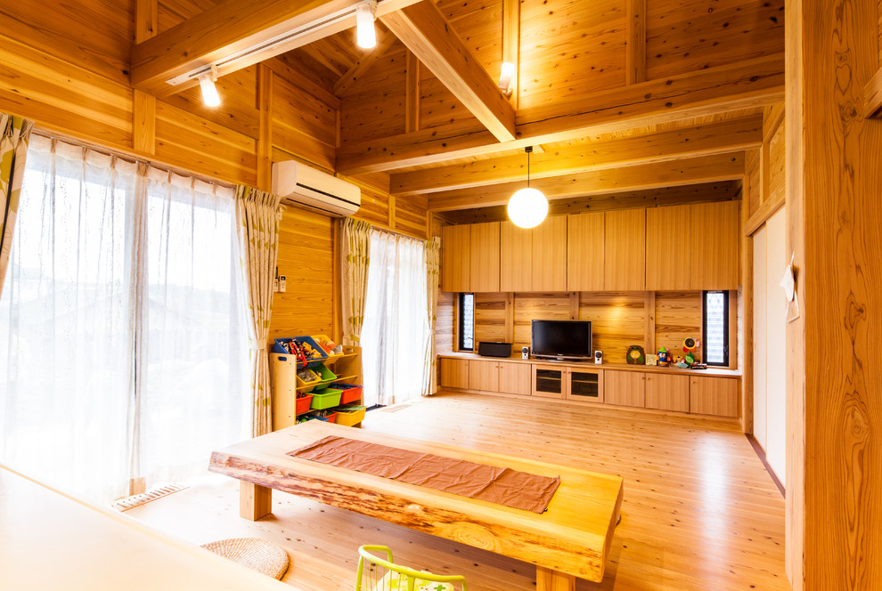 Foto di un soggiorno etnico con pareti marroni, pavimento in legno massello medio, TV autoportante e pavimento marrone